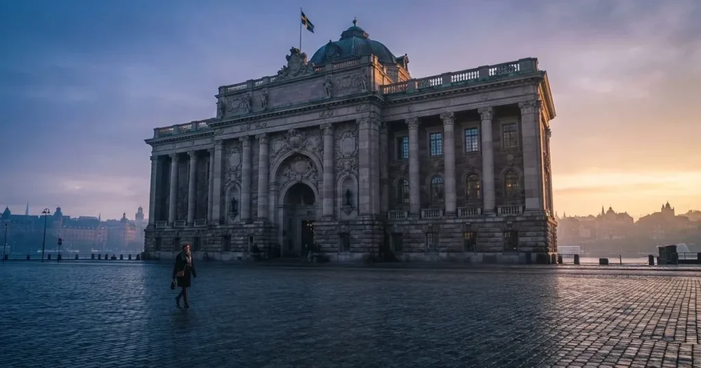 Stenfasad på en statlig byggnad i Stockholm vid gryning, höga pelare och ett tomt torg framför — casinon utomlands för svenskar